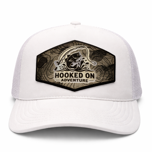 White trucker cap with 'Hooked on Adventure' logo on a white background