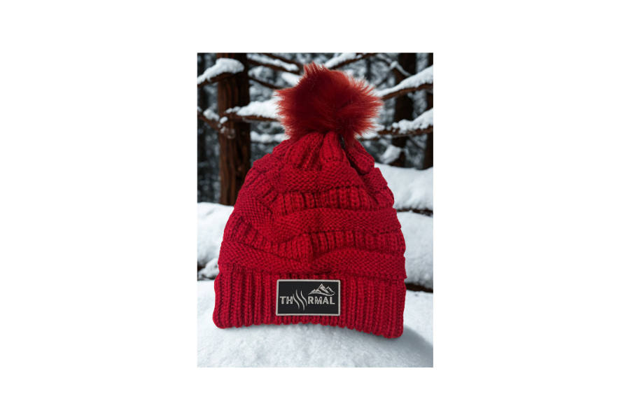 Red knit beanie with pom-pom on a snowy background
