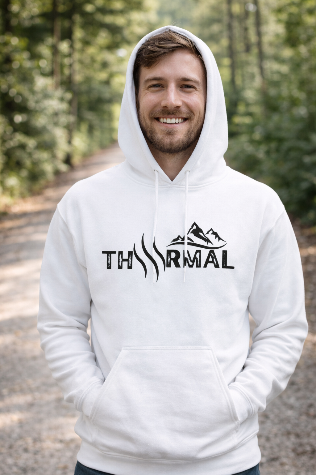 Person wearing a white hoodie with a logo in a forest setting
