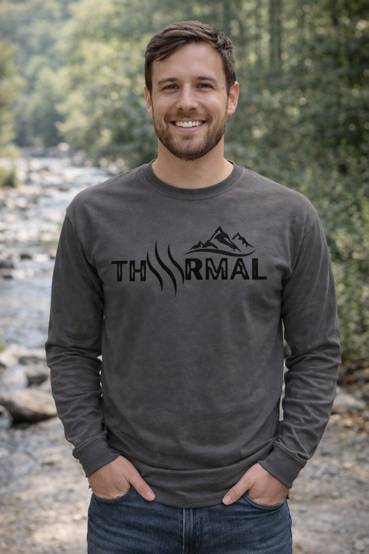 Man wearing a dark gray sweatshirt with 'THRMAL" logo outdoors